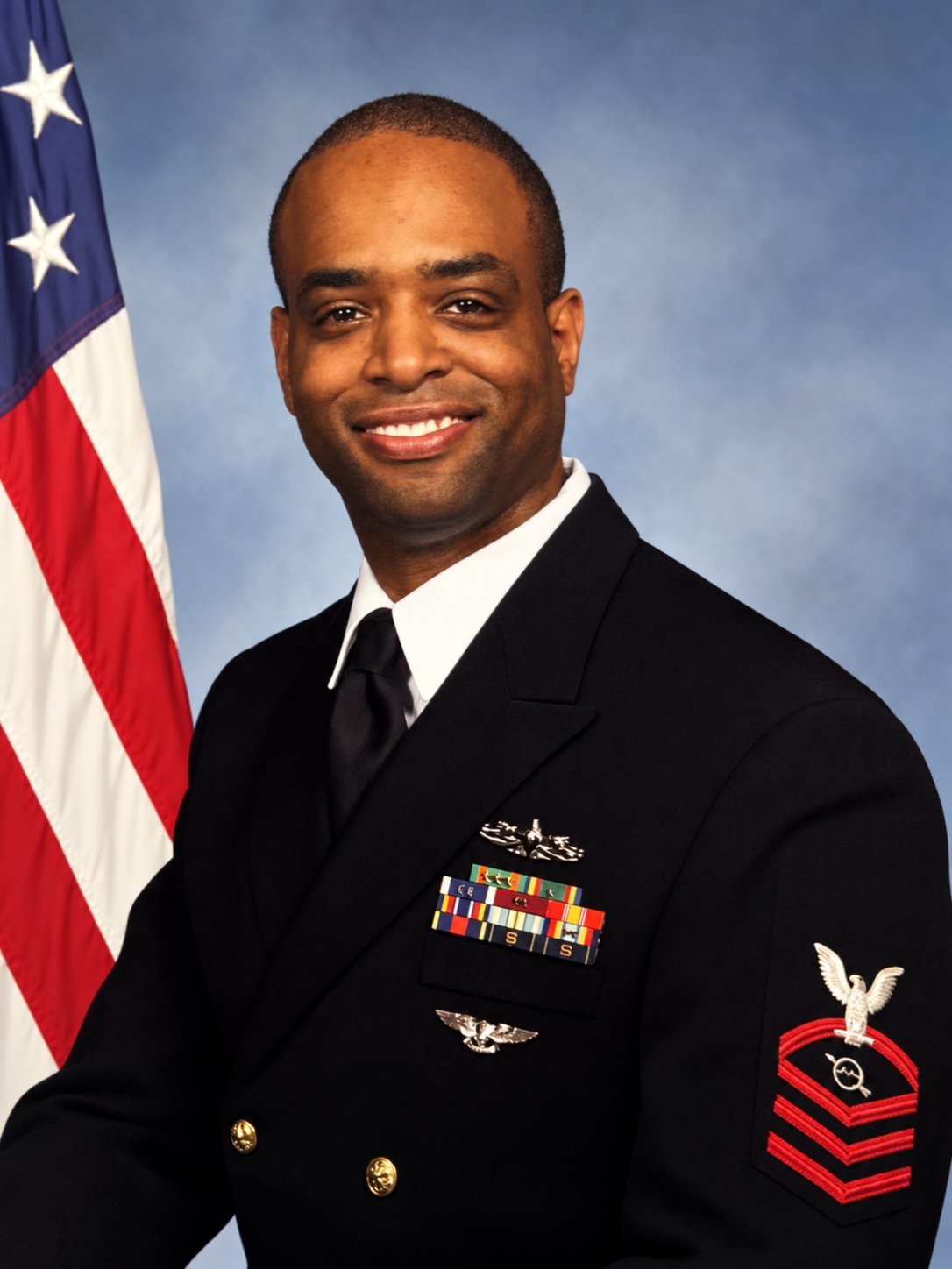 Steven Spencer, U.S. Navy Chief Petty Officer, in dress uniform with the American flag.